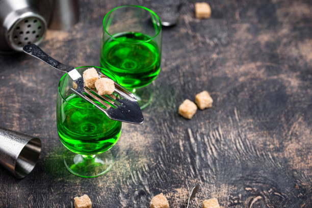 Glass of absinthe with cane sugar cubes on special spoon