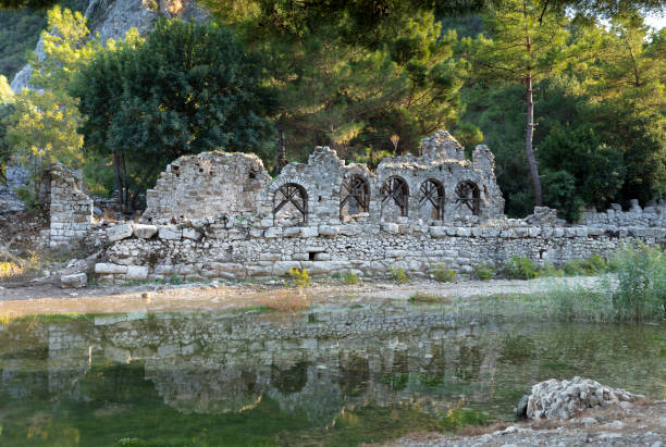 Ruins of the ancient city of Olympos in Cirali village in Antalya, Turkey\nRiver through Olympos antique city ruins. Ancient bridge. Kemer, Antalya, Turkey.