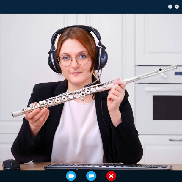 istock Screen interface programs for online learning, a woman leads a lesson on the flute. A music teacher in a black suit conducts a lesson for students over the Internet. 1226496433