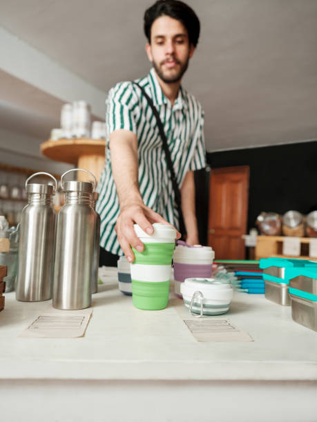 istock Young man holding reusable coffee cup in sustainable store 1226500560