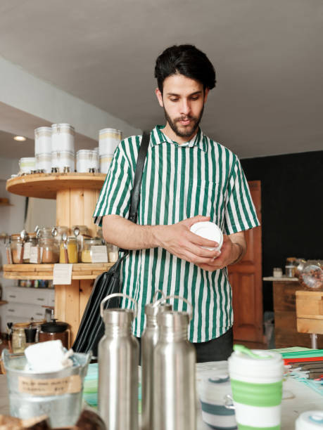 istock Young hispanic man looking at reusable cups in shop 1226500583