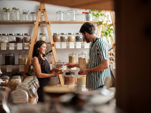 istock Happy hispanic employee helping young man in zero waste store 1226500608