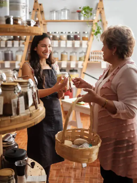 Photo of Happy employee helping hispanic customer in sustainable store