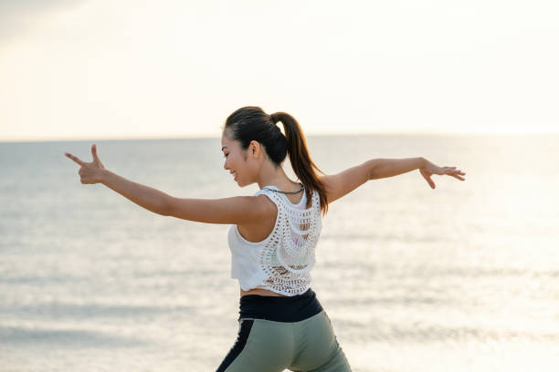 istock Young woman practicing yoga and stretching on the beach 1226504260