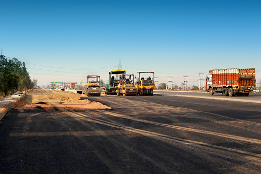 Sonipat, Haryana, India February 28, 2018 : Highway expressway under construction and some of road roller standing roadside.