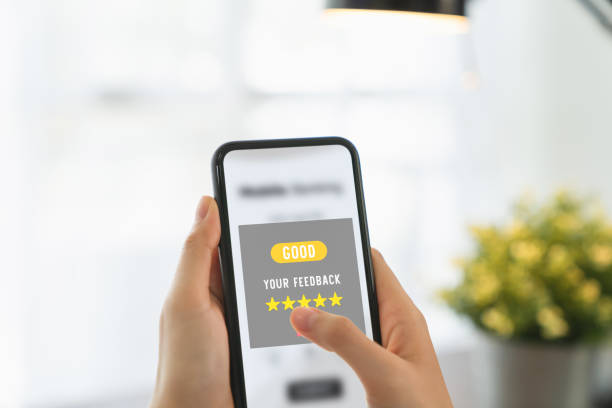 istock Hand holding smartphone and rate your feedback and show five star on application. 1226515320