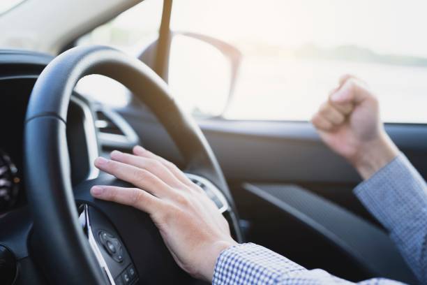 image of young man in a car, fist pump stock photo
