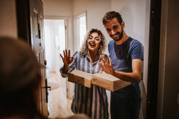 istock Happy young couple receiving packets from postal worker 1226525988