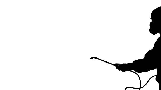 Medium shot. Walking in and out of the frame. Silhouette Disinfectant worker in protective suit making disinfection. Professional shot in 4K resolution. 53. You can use it e.g. in your medical, commercial video, business, presentation, broadcast