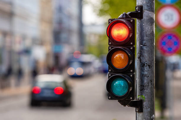 una città che attraversa con un semaforo, luce rossa in semaforo - stoplight foto e immagini stock