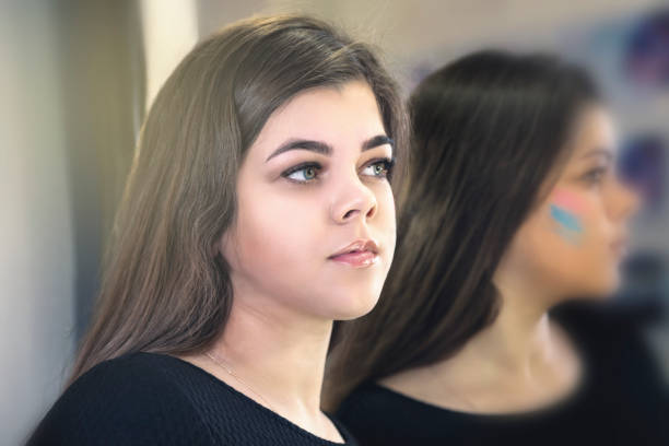 Woman with blue eyes is looing at herself in the mirror
