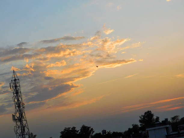 I Know This Photo Looks Unreal But Its real . Its a Beauty Of Nature . A Beautiful Sunset And A small bird and a tower with so much beautiful colours .