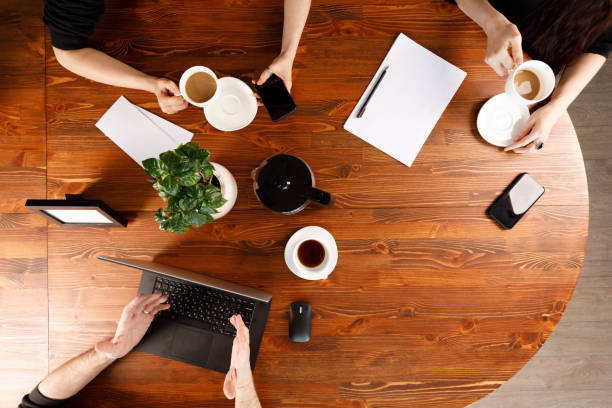 istock Group of business people working at desk, top view. Weekday work concept. Office stuff and gadgets nearby. 1226548193