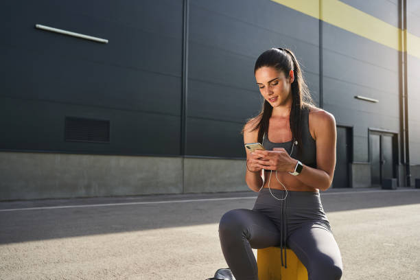 istock Charming female athlete surfing the net on mobile phone 1226548533
