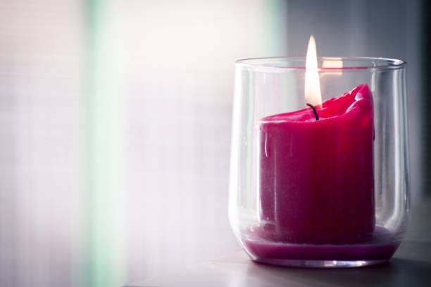 istock Burning red candle inside a clear glass vase. No people 1226549513
