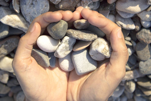 istock Woman hands touching stones on the beach. Grey stones 1226549747