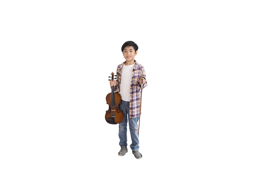 A portrait of a cute Asian elementary school student wearing a jeans and wearing a plaid shirt holding a violin. An isolated image with white background.