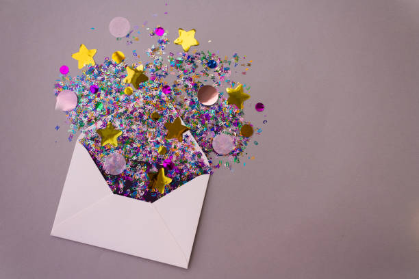 istock Opened white envelope with multicolored sparkle glitter confetti letters on pastel lilac background. Festive greeting concept. Flat lay style. Top view. Copy text 1226551860