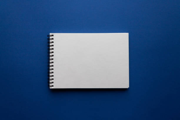 istock Open blank spiral notebook on trendy classic blue background. Minimalism. Flat lay style. Top view. Place for text 1226551894