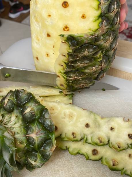 istock Large knife peeling whole pineapple on the desk in a kitchen 1226552308