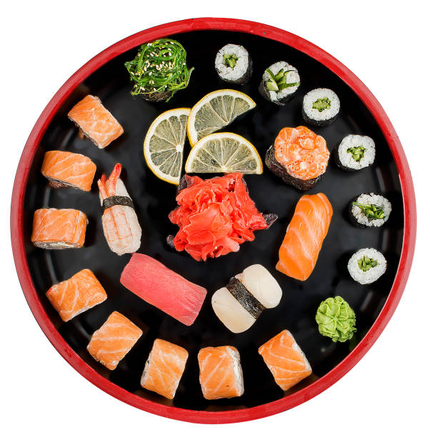 sushi set nigiri, petits pains et sashimi servis dans l’assiette ronde traditionnelle du japon noir sushioke. sur le fond blanc - susi photos et images de collection