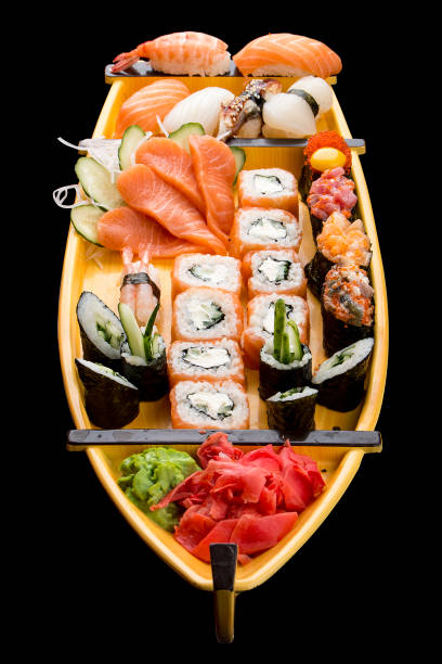 istock Sushi set in a wooden boat on a black background 1226553450