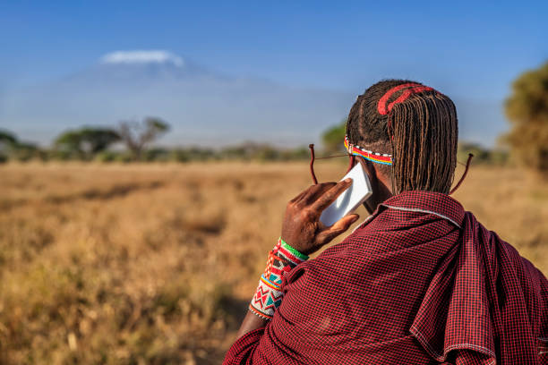 Warrior from Maasai tribe using mobile phone, Kenya, Africa