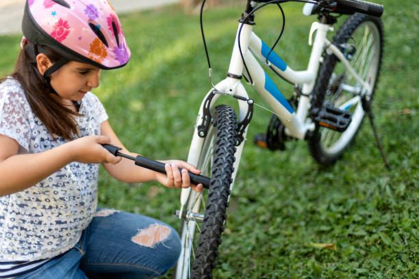 маленькая девочка ремонт велосипеда - bicycle bicycle pump inflating tire стоковые фото и изображения