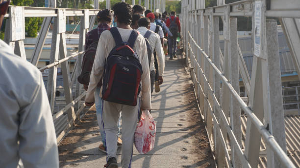 Indian migrant workers during COVID 19 Corona Virus nationwide lockdown returning back home via special trains or Bus. Social distancing and wearing masks at the Railway station. Indian Police on duty.