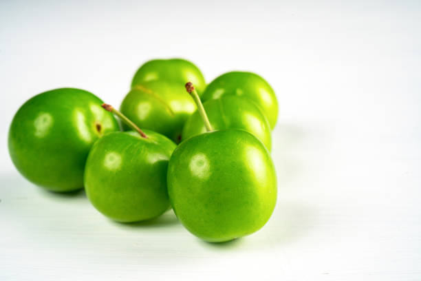 Close-up macro fresh green sour plum. Greengage on white background.
