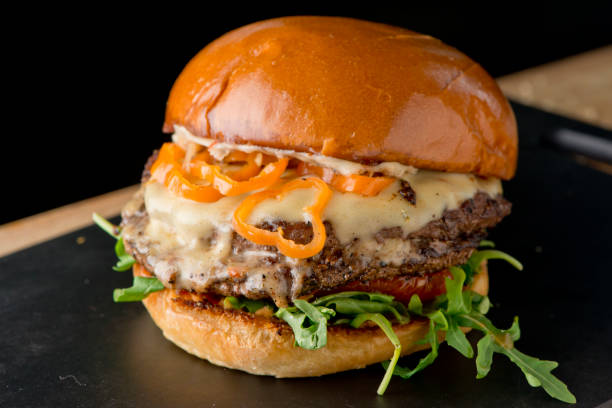 istock Bacon cheeseburger. Classic American style Burger with two patties, crispy Bacon, melted Swiss cheese, caramelized onions on a toasted brioche and served with crispy French fries. Bar favorite. 1226559645