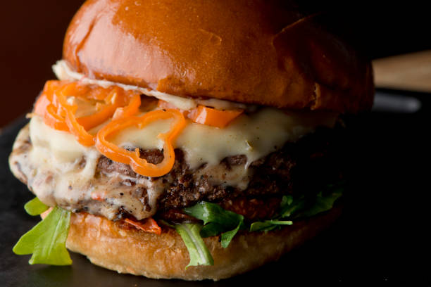 istock Bacon cheeseburger. Classic American style Burger with two patties, crispy Bacon, melted Swiss cheese, caramelized onions on a toasted brioche and served with crispy French fries. Bar favorite. 1226559663