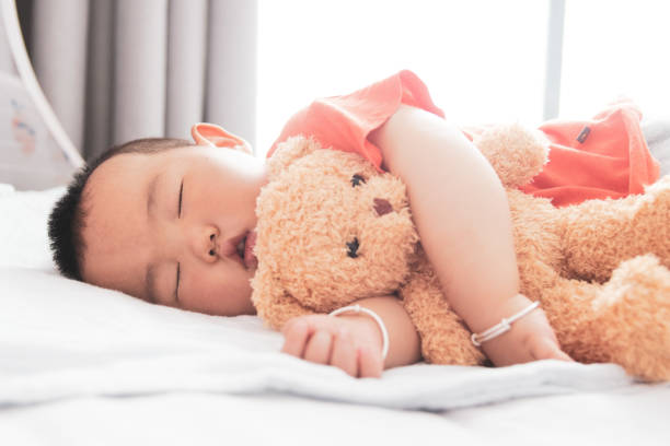 istock Little Asian baby boy sleeping with teddy bear 1226560642
