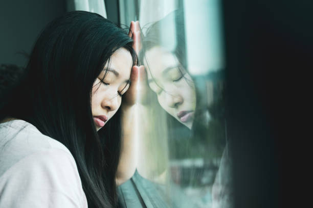 istock Sadness young woman by the window 1226560691