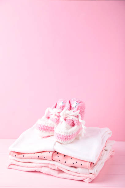 istock Baby clothes with booties on pink background with copy space 1226560719