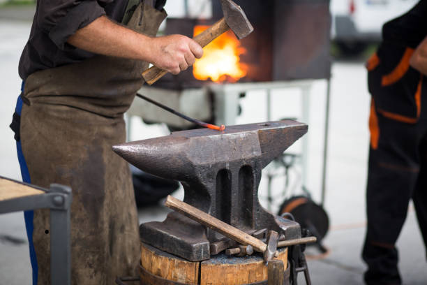 istock The blacksmith manually forging the molten metal on the anvil in smithy with spark fireworks 1226562022