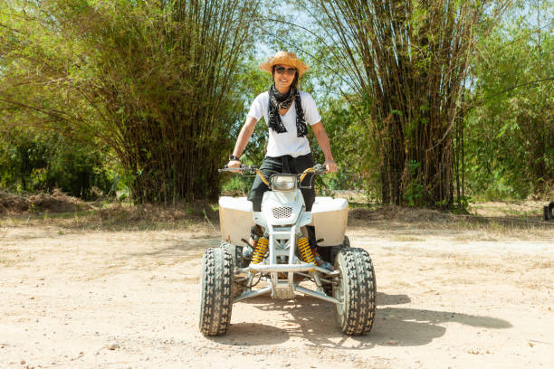 Asian woman riding on an ATV in a hot summer day
