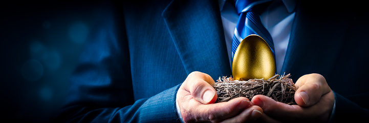 Hombre de negocios sosteniendo huevo de nido de oro photo