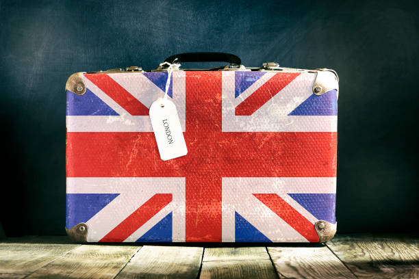 istock Old suitcase with English flag on wooden background. 1226566975