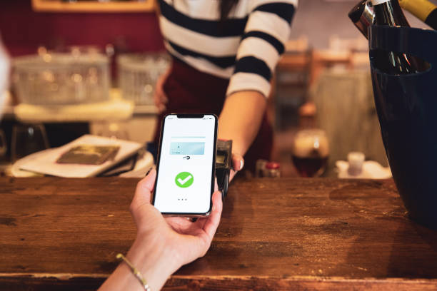 istock Woman in a cafe bar paying using contactless payment 1226568189