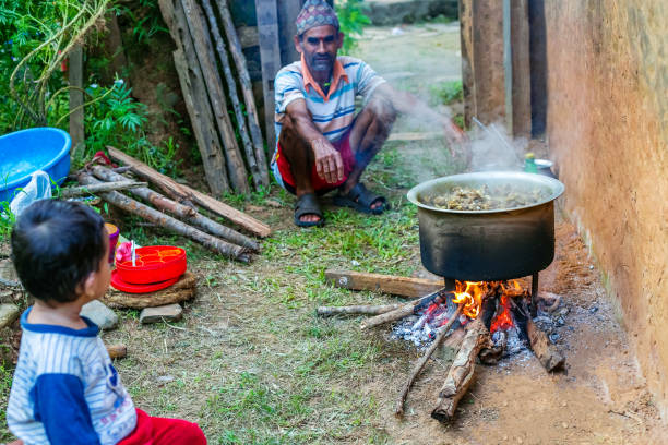 Gorkha,Nepal - October 6,2019: Old Man Cooking Mutton Curry in the rural village of Nepal. Mutton Curry.Selective Focus