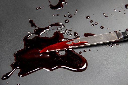 Knife with blood on the white background. Bloody background with knife - conceptual photo.