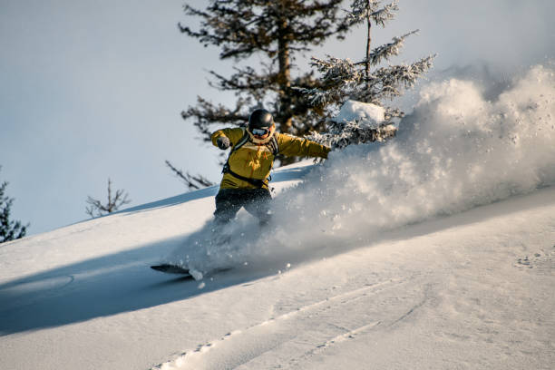istock Snowboarder in a yellow jacket slides down a mountain slope 1226571570
