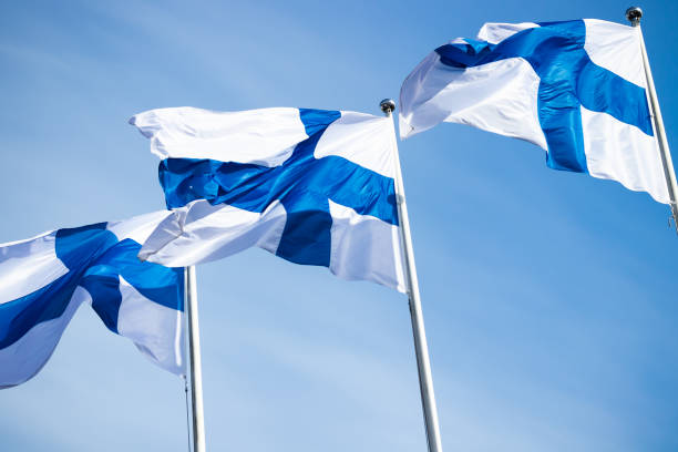 istock Three finnish national flags on the wind against the blue sky 1226575970