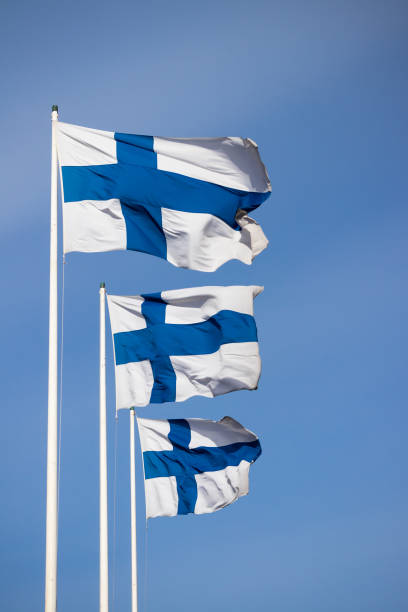 istock Three finnish national flags on the wind against the blue sky 1226576116