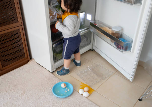 istock Baby boy with broken eggs on the kitchen floor 1226578151