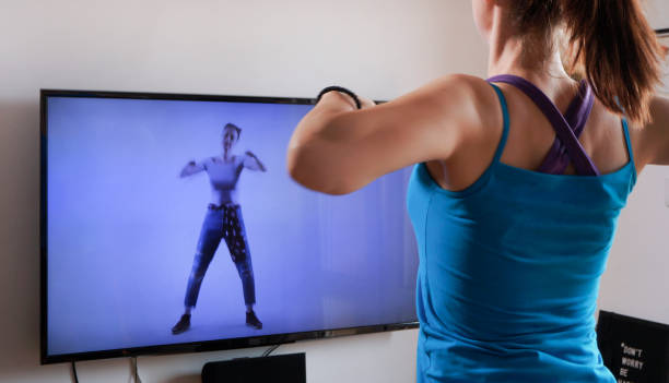 istock Woman doing workout in front of tv screen 1226578566