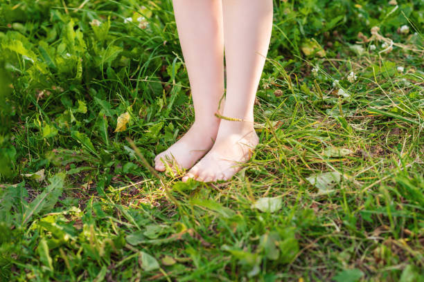 istock Barefoot of child standing on green grass. 1226579999