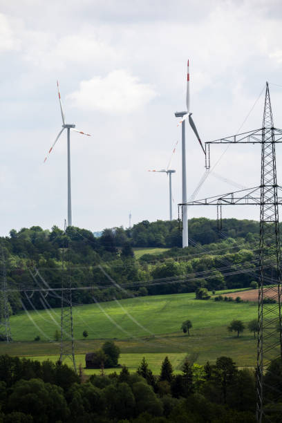 istock power pylon in the foreground and behind it a wind farm with wind turbines 1226580818