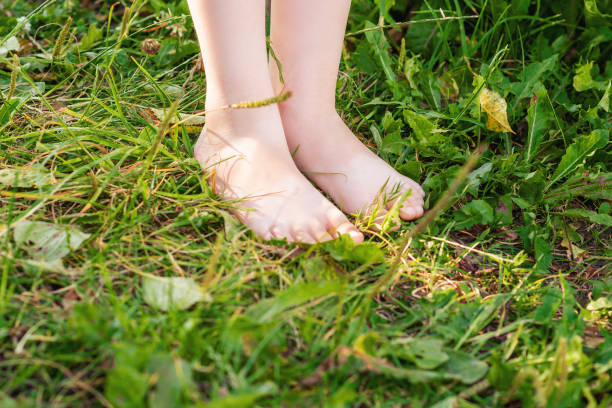 istock Barefoot of child standing on green grass. 1226580919
